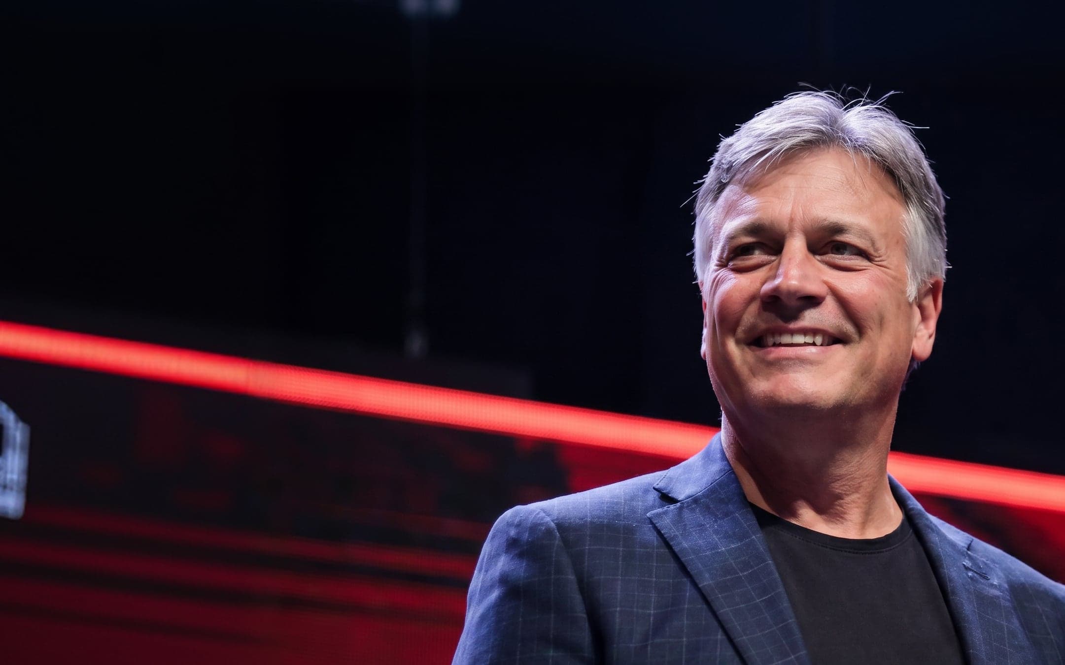 Michael Scarano smiling on stage under red stage lighting